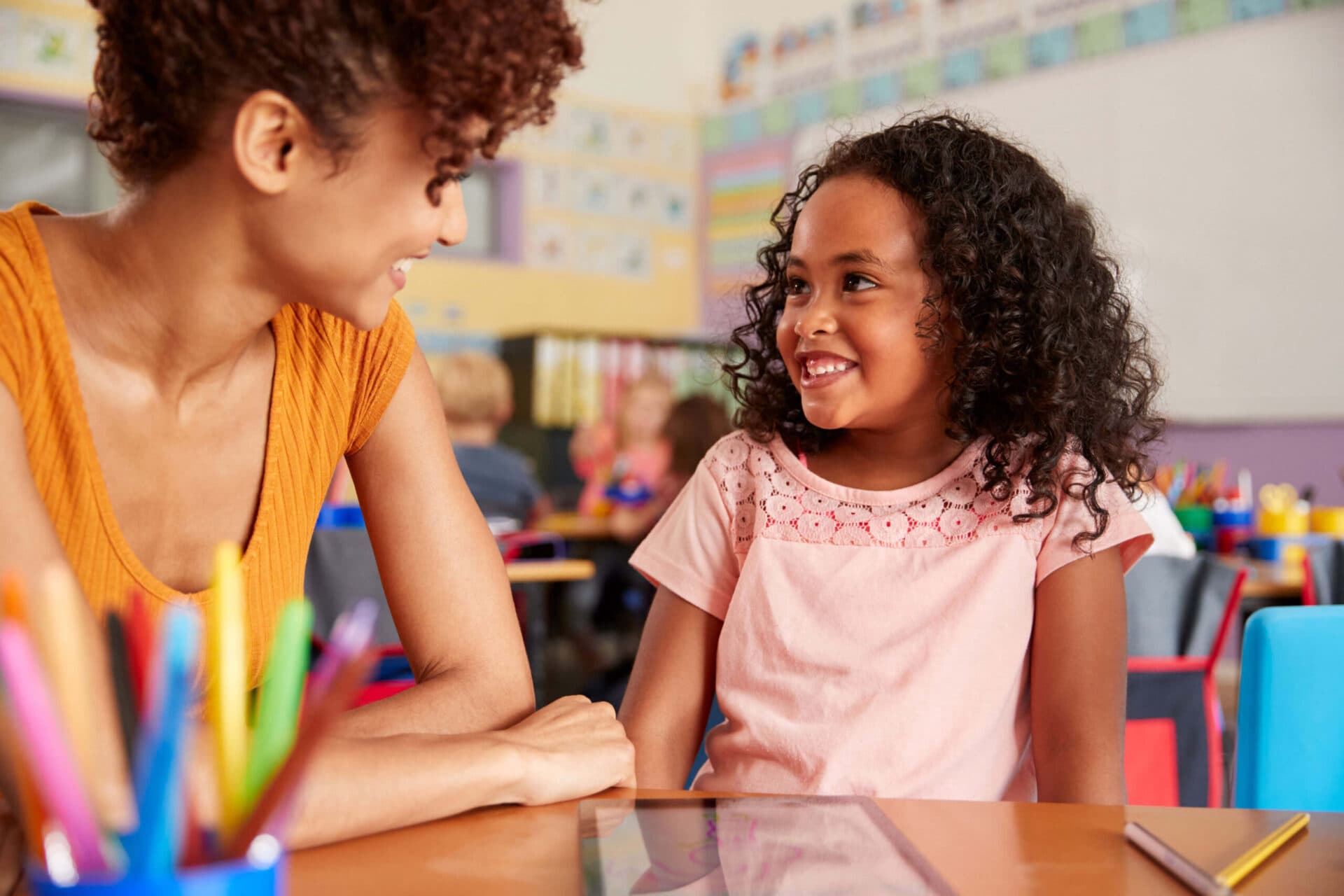 A teacher and a child smiling at each other in a Devine Schools classroom